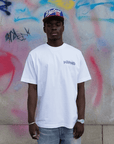 modelo chico con camiseta holgada blanca disanimed, con estampado morado hell invasion